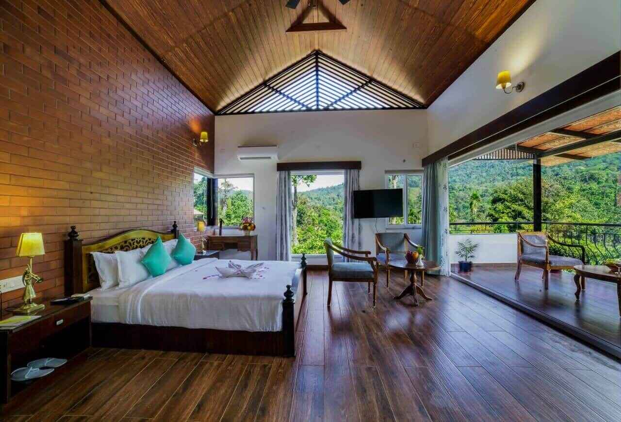 Premium Cottages: Spacious interiors with breathtaking views of the Charmadi Ghats from the balcony.